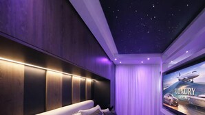 A modern bedroom with a starry ceiling, a large bed with multiple pillows, and a television displaying 'LUXURY LIVING'. - Legacy Marine 3 – Luxury Designer Penthouse in Zadar (Zadar)