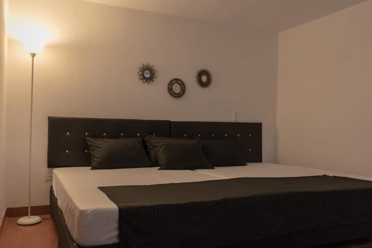 A bedroom with a bed, a bedside lamp, and wall decorations.
