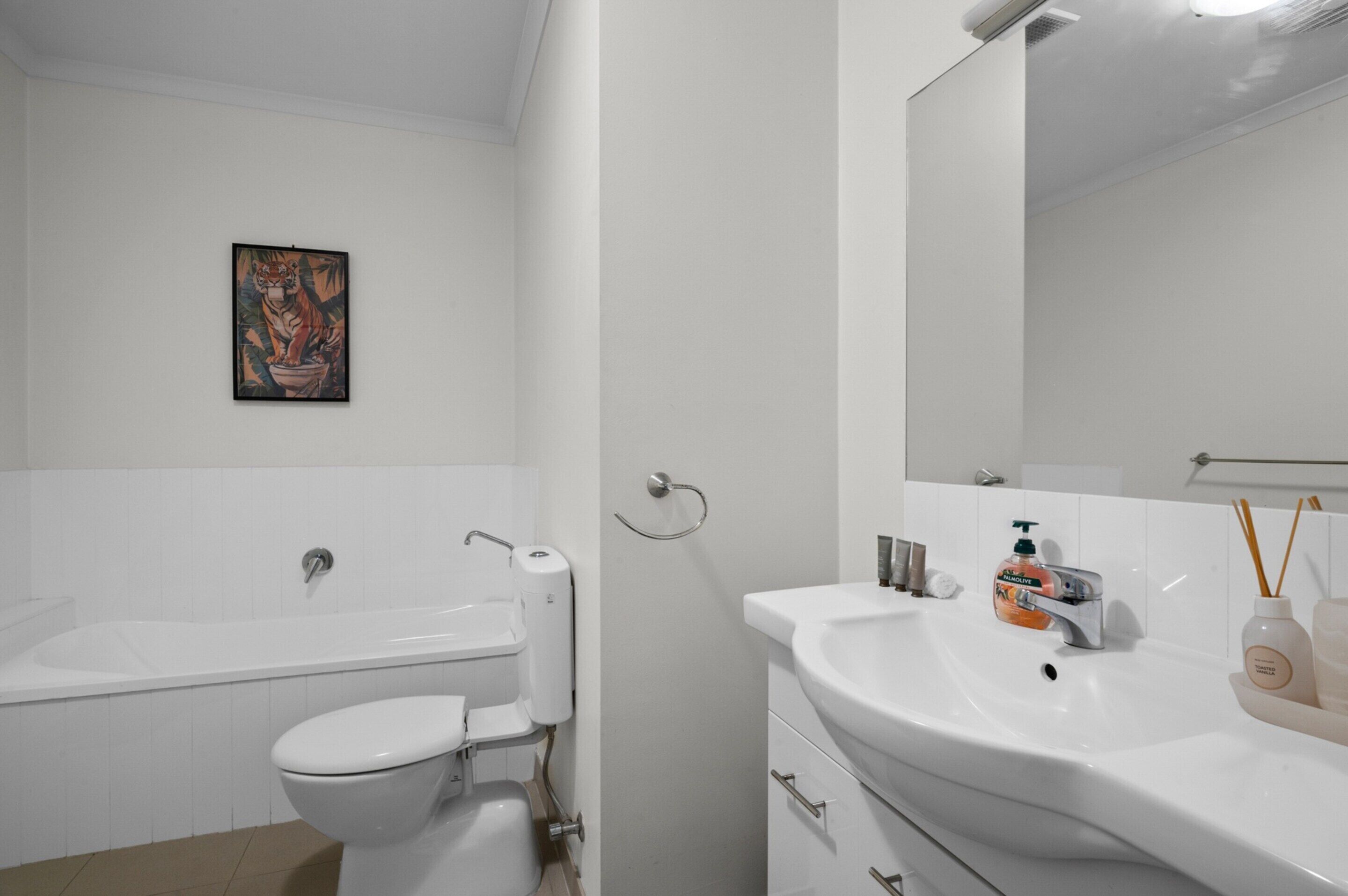 A modern bathroom with a bathtub, toilet, and sink.