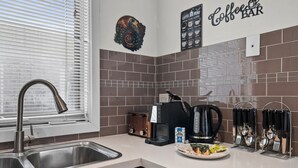A modern kitchen with a stainless steel sink, a coffee maker, and a toaster. - Spacious 3-bed Townhouse in Coburg (Melbourne)