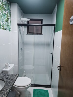 Un bagno piccolo con un water, una doccia e un lavandino.