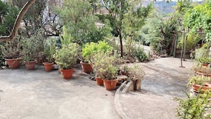 A courtyard with potted plants and a view of the surrounding landscape. - Casa Alma | Welcomely (Sas Murtas)