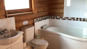 Et badeværelse med vask, toilet og badekar.