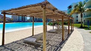 A beachside resort with a wooden pergola, a pool, and a sandy walkway. - Apartment with balcony overlooking crystal-clear lagoon and (Mazatlán)