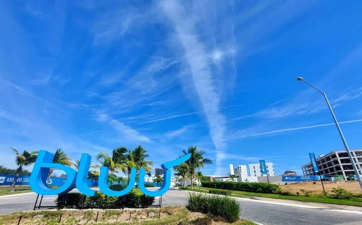 A clear blue sky with a large blue sign featuring the word "blu".