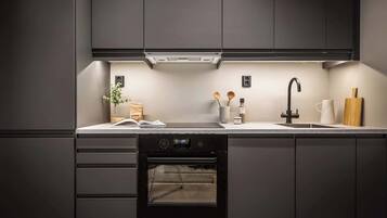 Cafetera o tetera, frigorífico, horno y placa de cocina
