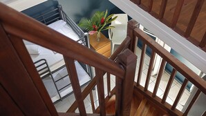 Una scala in legno con vista su una stanza sottostante.