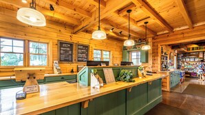 Un interno in stile baita con reception, soffitto in legno e mobili impiallacciati di verde.