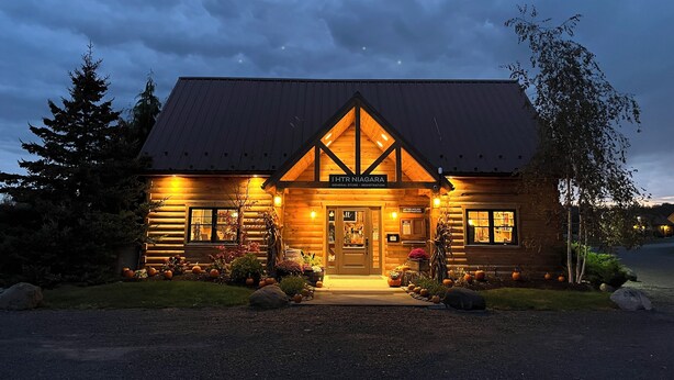 Un edificio in stile baita di legno con un cartello che recita 'IHRNIAGARA General Store - Registration'.