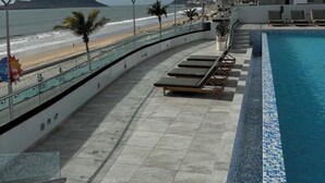 A rooftop pool with a view of the beach and ocean, surrounded by modern buildings. - Spectacular ocean view (Mazatlán)