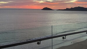 A coastal view with a sunset, calm sea, and distant landforms. - Spectacular ocean view (Mazatlán)