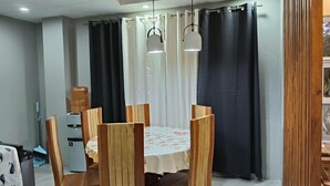 Un comedor con una mesa redonda, sillas de madera y un dispensador de agua.