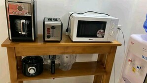 A kitchen counter with a coffee maker, toaster, and microwave. - Cozy Escape with WiFi & Smart TV (Dipolog City)
