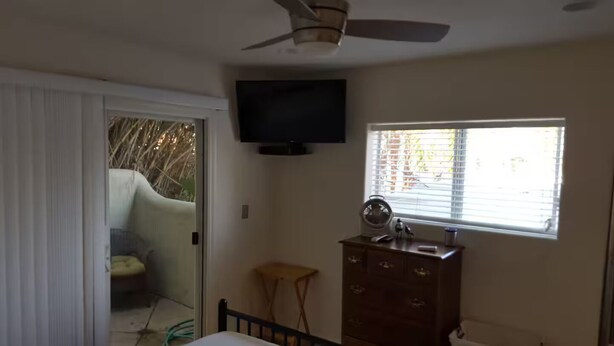 A bedroom with a bed, a dresser, a television, and a window. - SC Cozy Beach Apartment (San Clemente)