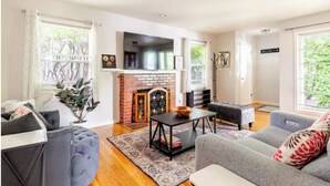 A living room with a fireplace, a sofa, a coffee table, and a TV.