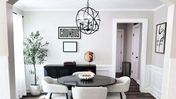 A dining area with a round table and four chairs, a hanging spherical light fixture, and a potted plant. - Cozy 2-bedroom bungalow in marvelous Columbus, GA (Columbus)