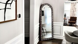 A room with a wooden floor, a white door, a mirror with a decorative frame, and a chair. - Cozy 2-bedroom bungalow in marvelous Columbus, GA (Columbus)