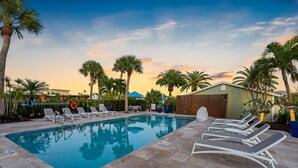 A pool area with lounge chairs and palm trees. - Hotel Studio (Second Level) - Unit D (Nokomis)