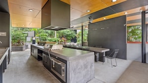 Una cocina moderna con una isla central, horno empotrado y vistas al exterior.