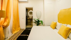 A hotel room with a bed, a mirror, a plant, and a bathroom visible through an open door. - Random Superior  By Dimorra (Naples)