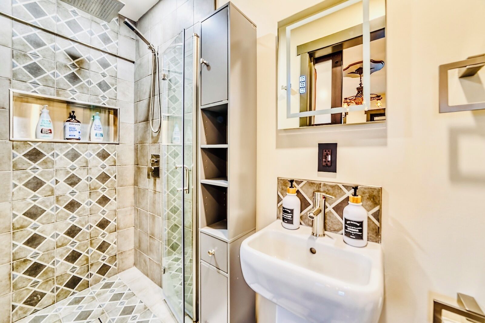 Un bany amb dutxa, un lavabo i prestatges amb productes de tocador.