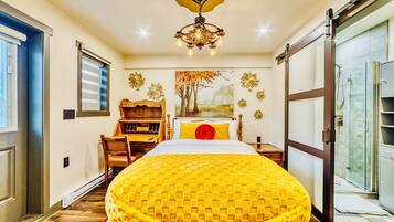 Habitación de hotel con una cama grande, un escritorio, una silla, una araña y un cuadro en la pared.