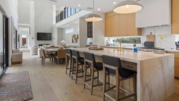 A modern kitchen with a large island, bar stools, and pendant lighting. - Lux 4100sqft Estate•Rooftop•Pool/Spa (Dallas)