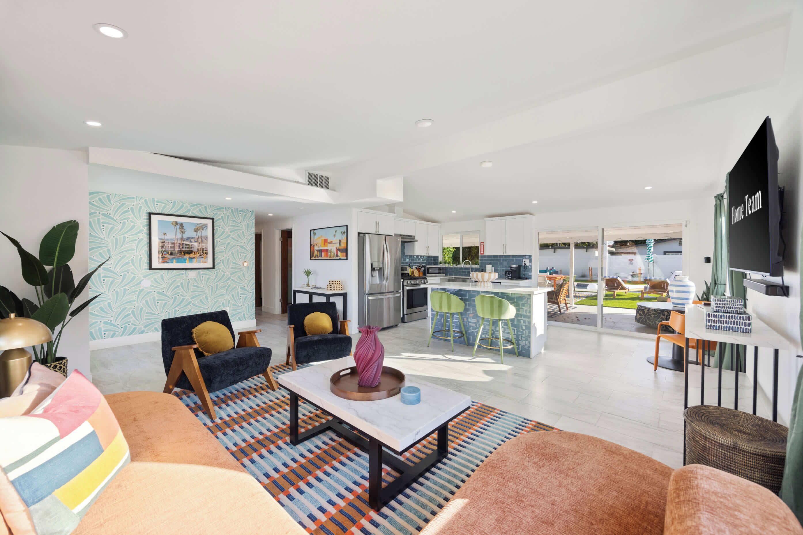 A modern living room with a sofa, a coffee table, and a dining area with chairs.