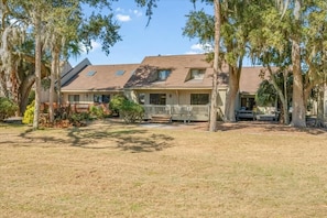 A two-story house with a covered porch and a fenced yard.