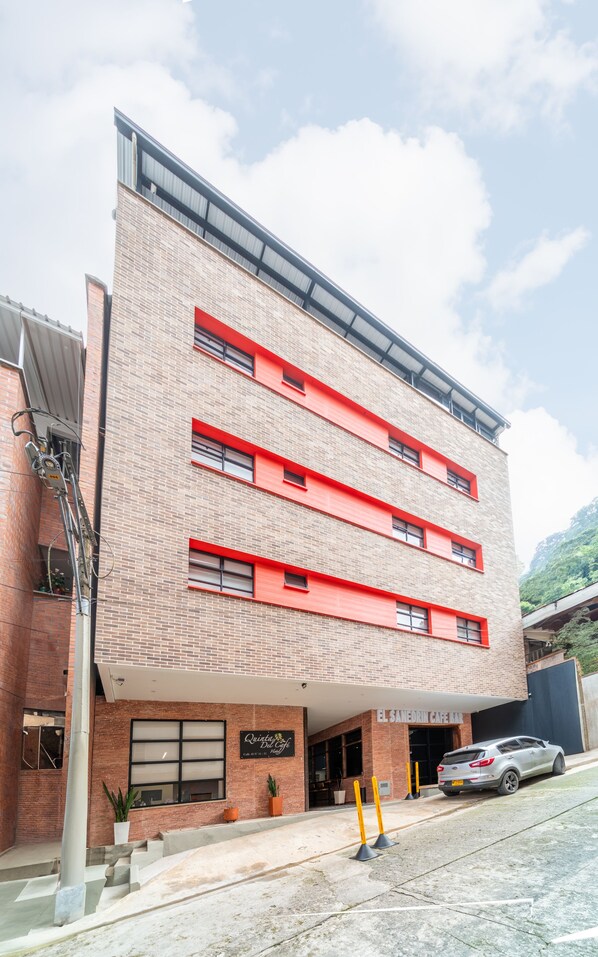 A multi-story building with a brick facade and red accents, featuring a sign for 'Quinta Del Café Hotel'. - Hotel Quinta Del Café (Fredonia)