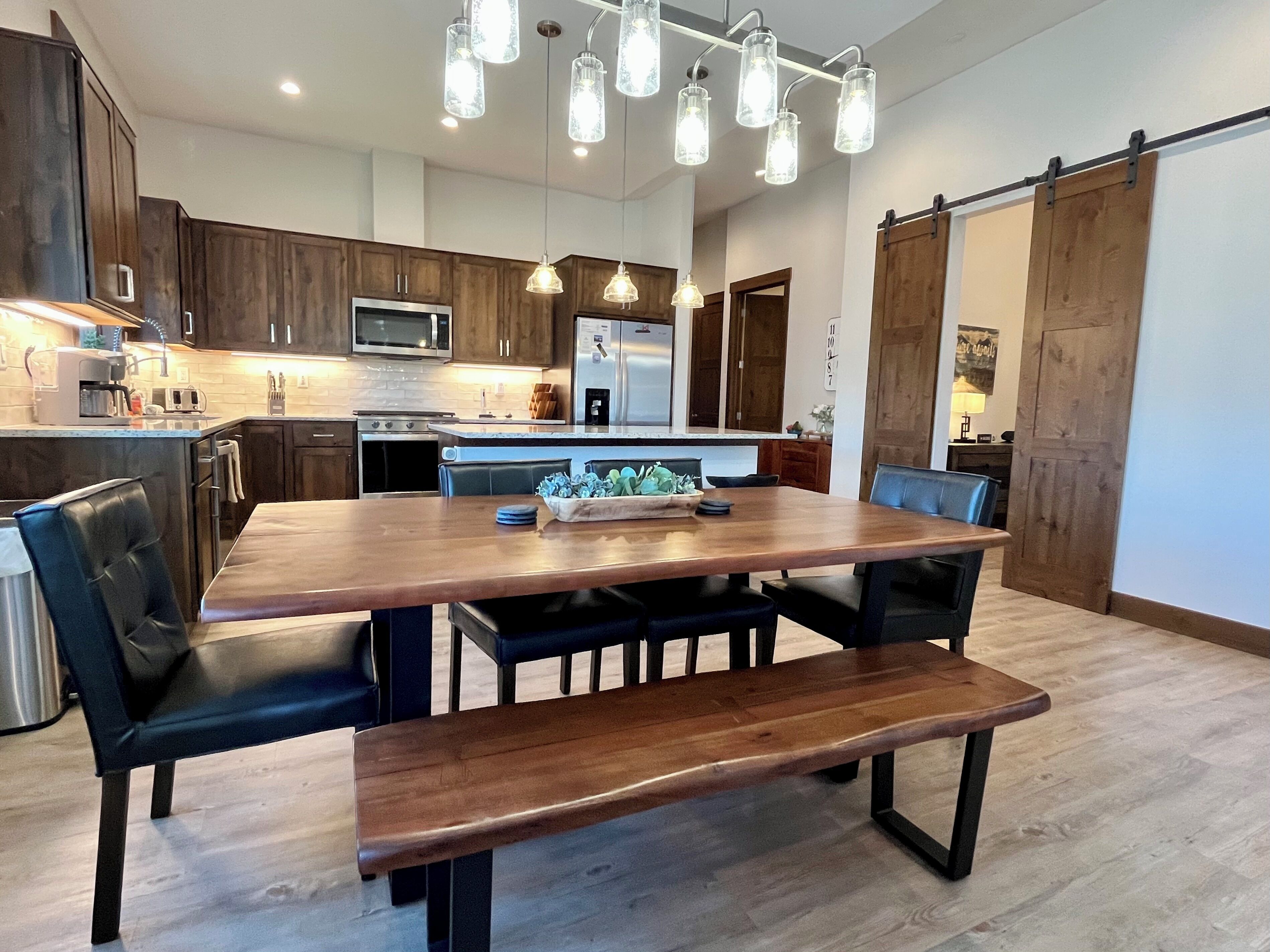 A modern kitchen with dark wooden cabinets, stainless steel appliances, and a central island.
