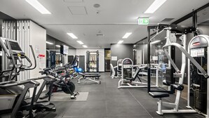 A gym with various exercise equipment, including treadmills, weight machines, and free weights. - Bright Inner-north Stay With Pool Access (Melbourne)