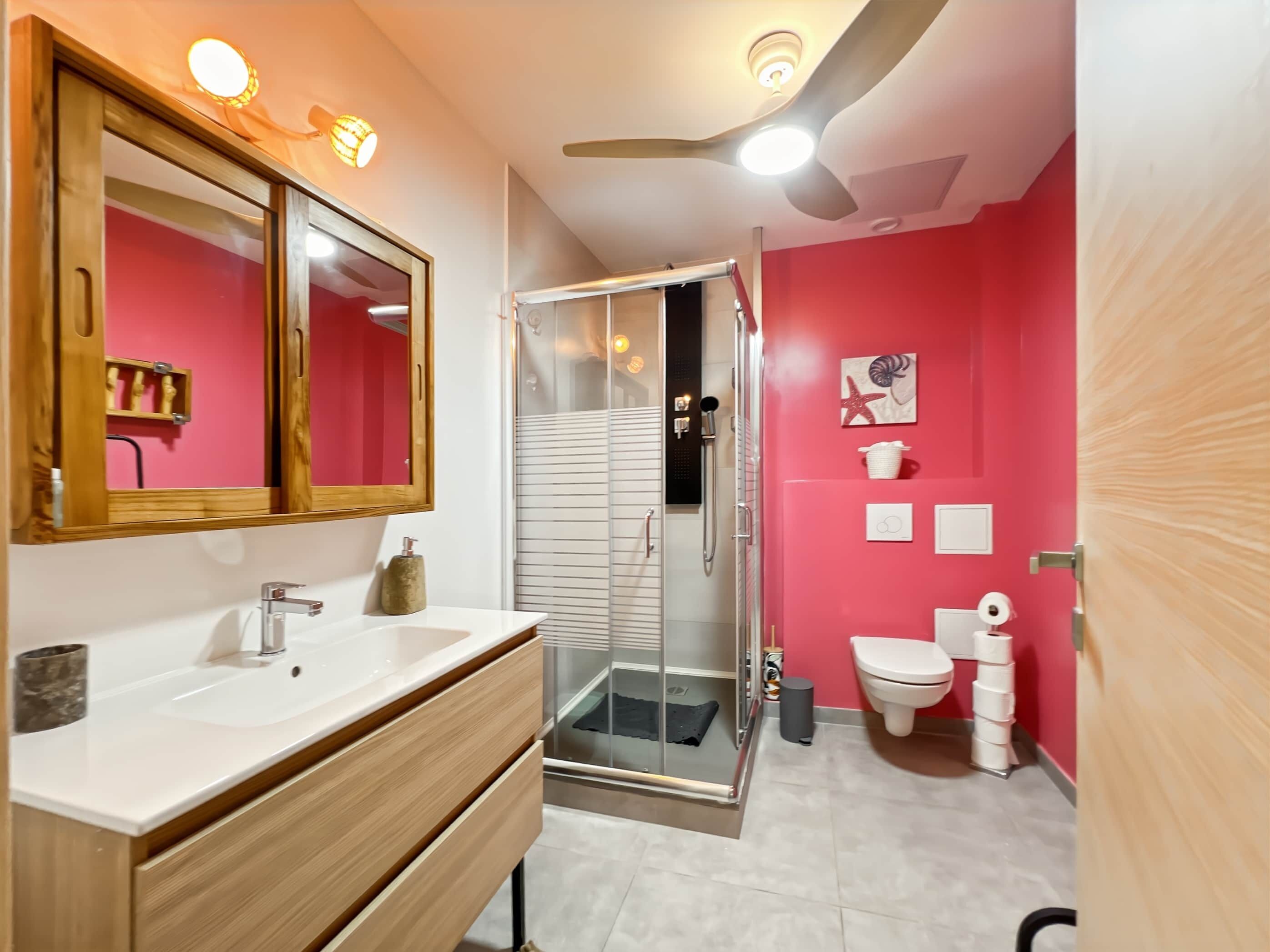 Un bagno moderno con un mobile lavabo, un lavandino e una doccia.