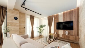 Un salon moderne avec un grand canapé, un téléviseur à écran plat fixé au mur et une petite table basse.