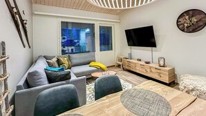 A modern living room with a sofa, coffee table, TV, and wooden furniture. - Pikkuhippu by Interhome (Pelkosenniemi)