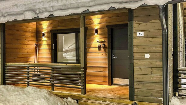 A wooden cabin with a bench outside, a door, and a window. - Pikkuhippu by Interhome (Pelkosenniemi)