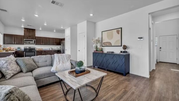 A modern living room with a gray sofa, a marble coffee table, and a dark blue cabinet.