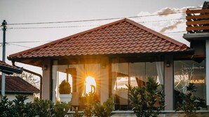Uma casa com telhado de telhas, janelas amplas e uma placa com a inscrição 'BELAJEC'.