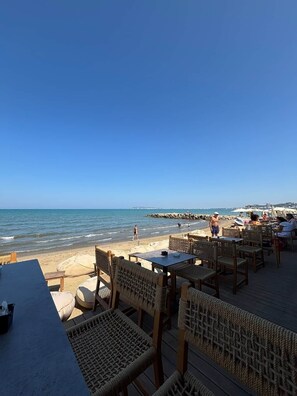 A beachside restaurant with outdoor seating overlooking the ocean. - Golem Living (Golem)