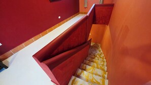 Eine Treppe mit roten Geländern und einem weiß-gelb gemusterten Boden.