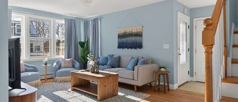 A living room with a sofa, coffee table, and a TV.