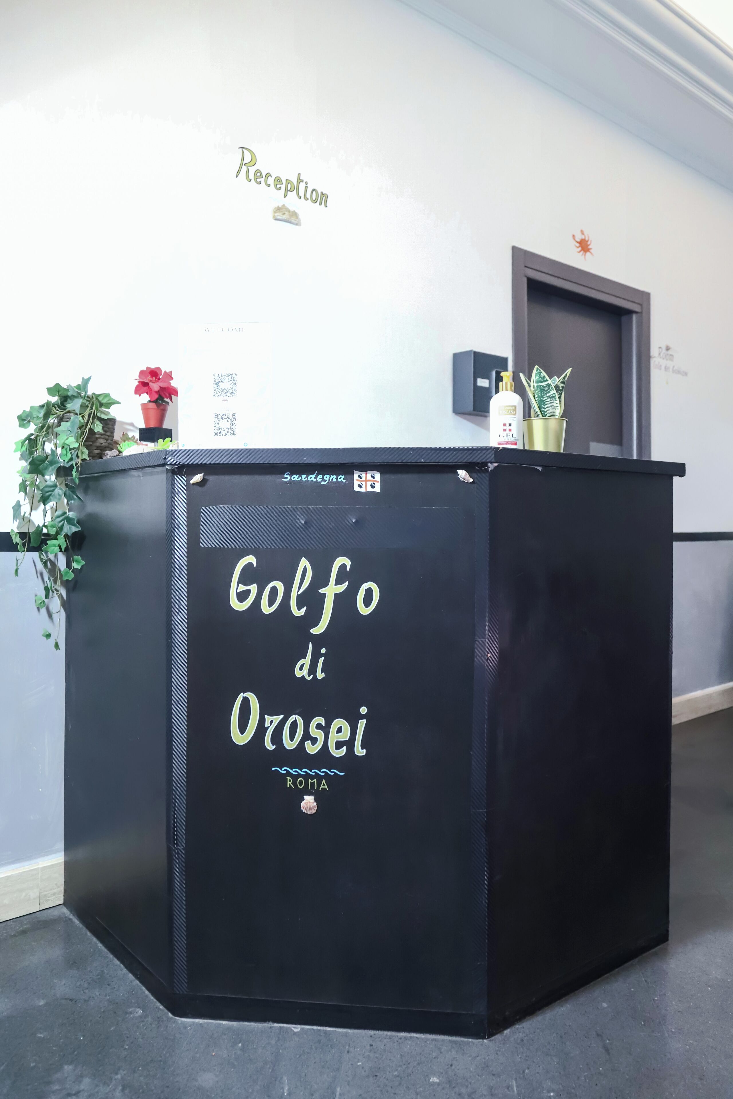 Un mostrador de recepción con el texto "Reception" y "Golf di Orosei ROMA".