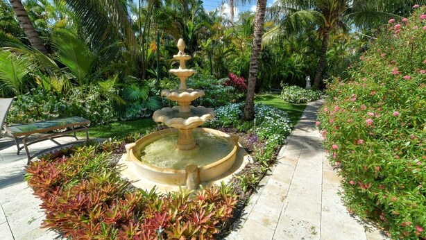 A garden with a central fountain, surrounded by various plants and a pathway. - 2 King Beds, Kitchen, Living & Dining Room, Yard, Heated Pool, WiFi, Apt#2112 (Wilton Manors)