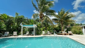 A clear blue pool with lounge chairs and a pergola, surrounded by palm trees. - 2 King Beds, Kitchen, Living & Dining Room, Yard, Heated Pool, WiFi, Apt#2112 (Wilton Manors)