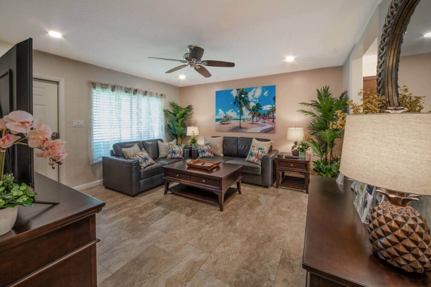 A living room with a sofa, coffee table, and a ceiling fan.