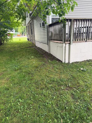 A residential property with a fenced yard, a wooden deck, and a small tree. - 3-bedroom cottage in Mayville, NY near Chautauqua Institution's Main Gate. (Mayville)
