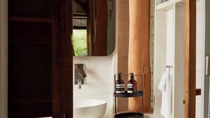 A bathroom with a wooden bench, a white sink, and a mirror. - Sohla Beach Hotel popoyo (Jiquelite)