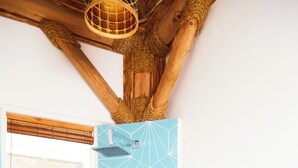 A bathroom with a geometric tile pattern, a window with blinds, and a wooden ceiling structure. - Sohla Beach Hotel popoyo (Jiquelite)