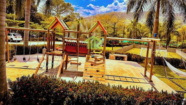 A playground with swings and a slide, surrounded by palm trees and a hammock. - SUMMER APARTMENT IN SANTA FE DE ANTIOQUIA (Santa Fé de Antioquia)