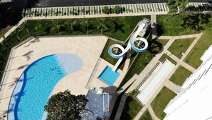 An aerial view of a swimming pool area with a circular water slide, surrounded by a landscaped garden and a building. - SUMMER APARTMENT IN SANTA FE DE ANTIOQUIA (Santa Fé de Antioquia)